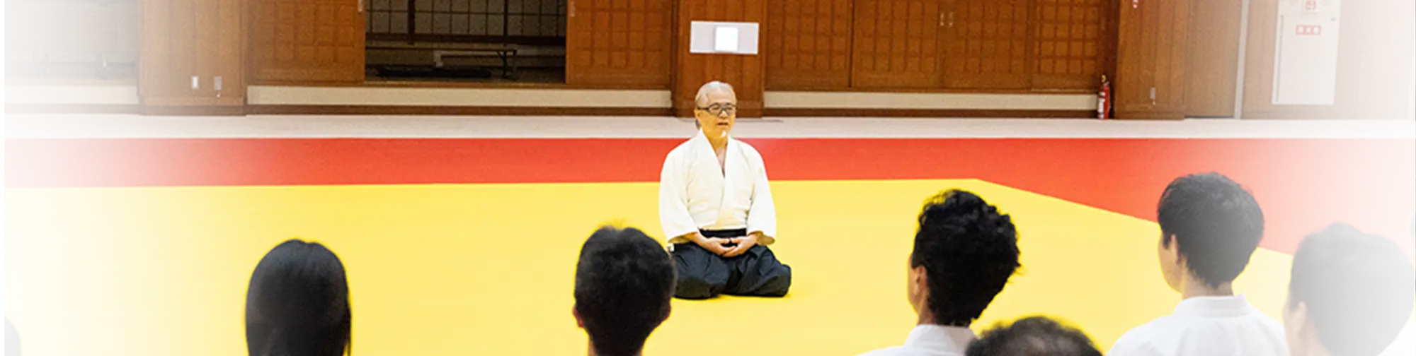 道場の中央で正座し、門下生に語りかける師範